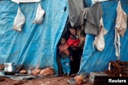 Pengungsi anak-anak Suriah melihat keluar dari tenda mereka di kamp pengungsi Kelbit, dekat perbatasan Suriah-Turki, di provinsi Idlib, Suriah, 17 Januari 2018. (Foto: dok).