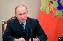 FILE - Russian President Vladimir Putin chairs a Security Council meeting in Moscow, June 16, 2017.