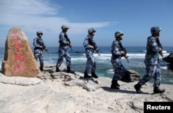 FILE - Soldiers of China's People's Liberation Army (PLA) Navy patrol at Woody Island, in the Paracel Archipelago, which is known in China as the Xisha Islands.