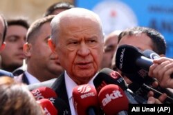 FILE - Devlet Bahceli, chairman of the Nationalist Movement Party or MHP, talks to the media after casts his ballot at a polling station in Ankara, Turkey, March 31, 2019.