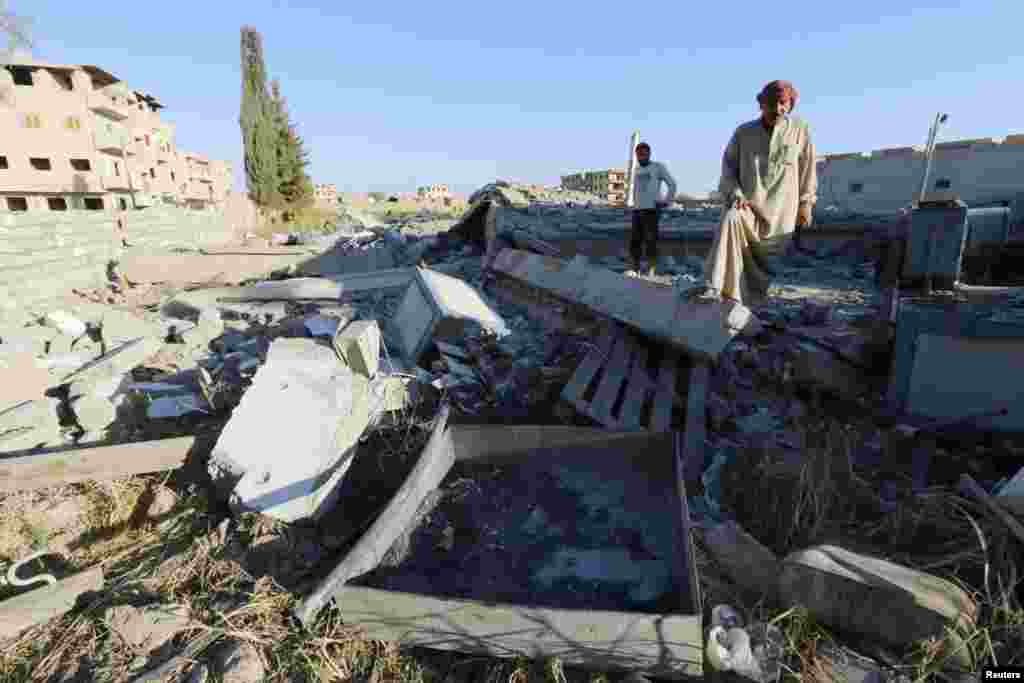 Abu Ismail, the owner of a plastics factory that was targeted on Sunday by what activists said were U.S.-led air strikes, examines the damage at his destroyed factory in the Islamic State&#39;s stronghold of Raqqa, Sept. 29, 2014. 