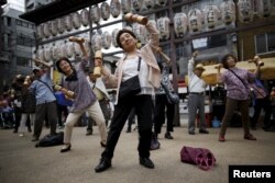 Warga lansia dan paruh baya di Jepang sedang berolahraga dalam acara promosi kesehatan memperingati “Hari Lansia” di sebuah kuil di distrik Sugamo, di Tokyo, 21 September 2015.