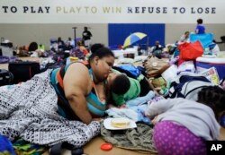 Annette Davis mencium putranya Darius, 3 tahun saat berlindung di sebuah penampungan di Miami setelah mengungsi dari rumahnya di Florida City menjelang Badai Irma tiba, 9 September 2017.