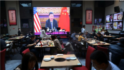 Presidenti kinez Xi shfaqet në ekranin e një restoranti në Pekin gjatë takimit virtual me Presidentin Biden (16 nëntor 2021)