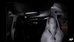 Image made from video, March 18, 2018, of a mounted camera provided by the Tempe Police Department, shows a human backup driver in Uber SUV looking down seconds before it hit a woman in Tempe, Arizona.