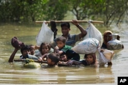 A Rohingya family reaches the Bangladesh border after crossing a creek of the Naf river on the border with Myanmar, in Cox's Bazar's Teknaf area, Sept. 5, 2017.