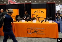 Attendees walk by a display of AR-15's and AR-10's at the National Rifle Association convention in Dallas, May 4, 2018.