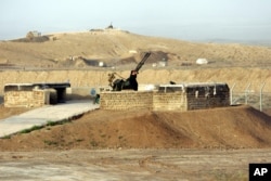 FILE - A security officer guards Iran's nuclear enrichment facility in Natanz, April 7, 2007.