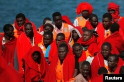 FILE- Migrants, part of a group intercepted aboard two dinghies off the coast in the Mediterranean Sea, stand on a rescue boat upon arrival at the port of Malaga, Spain, June 9, 2018.