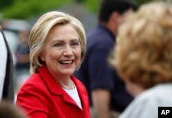 FILE - Democratic presidential candidate Hillary Rodham Clinton greets a spectator at a Fourth of July parade, July 4, 2015, in Gorham, N.H.