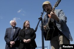 U.S. Democratic presidential candidate Bernie Sanders and his wife, Jane, listen as Guy Forsyth performs "This Land Is Your Land" at a campaign rally in Austin, Texas, Feb. 27, 2016.