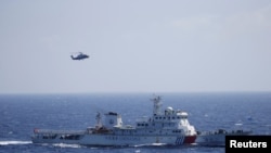 A Chinese ship and helicopter are seen during a search and rescue exercise near Qilian Yu subgroup in the Paracel Islands, which is known in China as Xisha Islands, South China Sea, July 14, 2016.