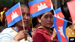 FILE - Garment workers welcome Prime Minister Hun Sen outside of Phnom Penh, Cambodia, Wednesday, Aug. 30, 2017. Hun Sen is on a country-wide trip to visit the nation's factory workers to hear their hopes and concerns in person. (AP Photo/Heng Sinith)