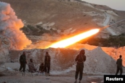 FILE - Free Syrian Army fighters launch a Grad rocket from Halfaya town in Hama province, towards forces loyal to Syria's President Bashar al-Assad stationed in Zein al-Abidin mountain, Syria, Sept. 4, 2016.