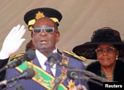 FILE - Zimbabwe President Robert Mugabe (L) and his wife Grace look on during the Defense Force's 36th Anniversary celebrations in the capital Harare, Zimbabwe, Aug. 9, 2016.