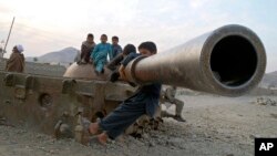 Afghan children play on the remains of a Soviet tank in the Behsood district of Jalalabad, Afghanistan, Feb 18, 2013.