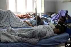 Injured men receive treatment at a hospital after a clash between Taliban and security forces in Kunduz province, Afghanistan, April 13, 2019.