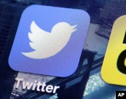 FILE - This Oct. 18, 2013, file photo, shows a Twitter app on an iPhone screen in New York.