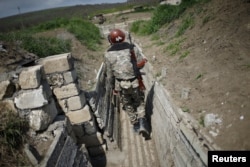FILE - Ethnic Armenian soldiers walk in a trench at their position near Nagorno-Karabakh's boundary, April 8, 2016.