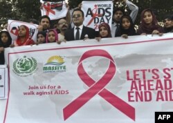 FILE - Pakistani social activists carry placards during a rally to raise awareness on World AIDS Day in Lahore, Dec. 1, 2016.