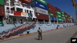 FILE - A Pakistan Navy soldier stands guard next to a loaded Chinese ship, at Gwadar port, about 700 kilometers (435 miles) west of Karachi, Pakistan, Nov. 13, 2016. 