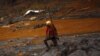 FILE - A rescue worker searches for victims at Bento Rodrigues district that was covered with mud after a dam owned by Vale SA and BHP Billiton Ltd burst, in Mariana, Brazil, Nov. 8, 2015. 