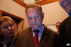 Republican U.S. Senate candidate Roy Moore, center, looks at election returns with staff during an election-night watch party at the RSA activity center, Dec. 12, 2017, in Montgomery, Alabama.