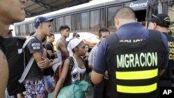 Cuban migrants wait to board a bus to take them to a shelter, outside an immigration office at the border between Costa Rica and Nicaragua, in Penas Blancas, Costa Rica, Nov. 25, 2015.
