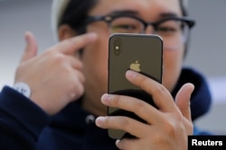An attendee uses a new iPhone X during a presentation for the media in Beijing, China, Oct. 31, 2017.