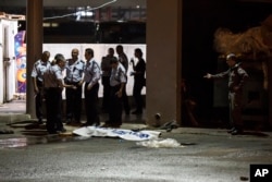 FILE - Israeli police stand by the shrouded body of Palestinian attacker in Beersheba, Israel, Oct. 18, 2015.