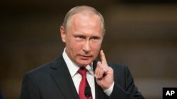 In this file photo from Monday, May 29, 2017, Russian President Vladimir Putin gestures as he speaks during a shared news conference with French President Emmanuel Macron at the Palace of Versailles, near Paris, France. (AP Photo/Alexander Zemlianichenko)