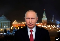 In this photo released by Kremlin Press service via Sputnik agency, Russian President Vladimir Putin speaks during a recording of his annual televised New Year's message in the Kremlin in Moscow, Jan. 31, 2018.