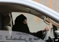 FILE - A woman drives a car on a highway in Riyadh, Saudi Arabia, as part of a campaign to defy Saudi Arabia's ban on women driving, March 29, 2014.