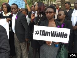 A Kenyan holds a placard in tribute to fellow lawyer Willie Kimani, who allegedly died at the hands of police in late June. Kenyan lawyers marched in protest in Nairobi's streets, July 6, 2016. (J. Craig/VOA)