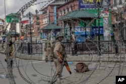 Indian Paramilitary soldiers are seen through barbed wire in Srinagar, Indian-controlled Kashmir, May 19, 2018.