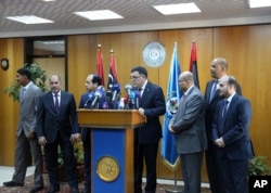 FILE - Fayez Seraj, flanked by members of the Presidential Council, speaks during a news conference at the Mitiga Naval Base in Tripoli, Libya, March, 30, 2015.