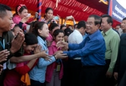 FILE - Prime Minister Hun Sen greets garment workers during a visit to a factory outside of Phnom Penh, Cambodia, Wednesday, Aug. 30, 2017.