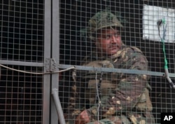 FILE - An Indian army soldier looks from inside an army vehicle at the Indian air force base in Pathankot, Jan. 4, 2016, on the third day of an attack by militants.