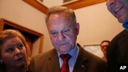 Republican U.S. Senate candidate Roy Moore, center, looks at election returns with staff during an election-night watch party at the RSA activity center, Dec. 12, 2017, in Montgomery, Ala.