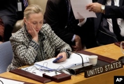FILE - In this March 12, 2012, file photo, then-secretary of state Hillary Clinton checks her mobile phone after her address to the Security Council at United Nations headquarters. Her use of a private email server for official correspondence at the time has become a centerpiece of the presidential election campaign.