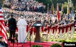 U.S. President Barack Obama, left, and Pope Francis watch onstage as the "Old Guard" fife and drum corps marches past during an official welcome ceremony on the South Lawn at the White House in Washington, Sept. 23, 2015.