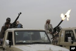 Pejuang pemberontak Houthi menembakkan senapannya ke udara selama berlangsungnya pertemuan yang bertujuan memobilisasi lebih banyak pejuang untuk gerakan Houthi, di Sanaa, Yaman, Kamis, 1 Agustus 2019.