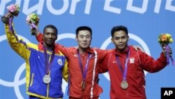 Eko Yuli Irawan yang meraih perunggu (kanan) mengaku masih menderita cedera retak pada tulang keringnya pada saat tampil di Olimpiade, Senin (30/7).