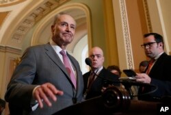 FILE - Senate Democratic Minority Leader Chuck Schumer (New York), left, pauses while speaking during a media availability on Capitol Hill, May 8, 2018, in Washington.