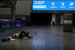 Seorang tunawisma berbaring di luar peron kereta Amtrak di Stasiun Washington Union menyusul pengumuman keadaan darurat karena pandemi virus corona, di Washington, 16 April 2020. (Foto: Tom Brenner/Reuters)