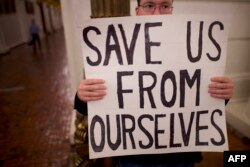 FILE - A Donald Trump protester joins demonstrators inside the Pennsylvania Capitol Building before electors arrive to cast their votes from the election in Harrisburg, Pennsylvania, Dec. 19, 2016.