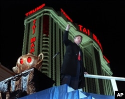 FILE - Donald Trump ascends the stairs with his fist raised from the genie's lamp after opening the Trump Taj Mahal Casino Resort in a spectacular show of fireworks and laser lights in Atlantic City, N.J., on April 5, 1990. Behind Trump is the 42-story hotel.