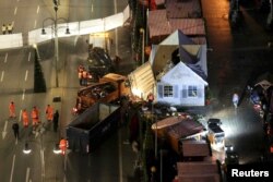 Workers clear the site of the Christmas market in Berlin, Germany, Dec. 21, 2016, after a truck plowed through a crowd at the Christmas market Monday night.