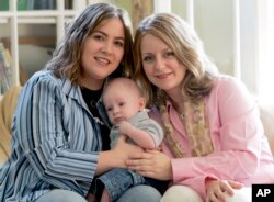 FILE - Cari Searcy, left, and Kim McKeand pose for a portrait with their son, Khaya, in Mobile, Ala., May 4, 2006.