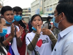 លោក ហ៊ុន វណ្ណៈ សមាជិក​យុវជន​ខ្មែរ​ថាវរៈ រាប់ពី​ឆ្វេងដៃ​ទៅ ឈរ​នៅ​កណ្តាល កំពុង​ជជែក​ជាមួយ​អាជ្ញាធរ​ផ្សារ​អូឡាំពិក ក្នុង​ទីក្រុង​ភ្នំពេញ​ នៅ​ថ្ងៃ​ទី​១២ ខែសីហា​ ឆ្នាំ​២០២០។ (ហ៊ុល រស្មី/វីអូអេ)​
